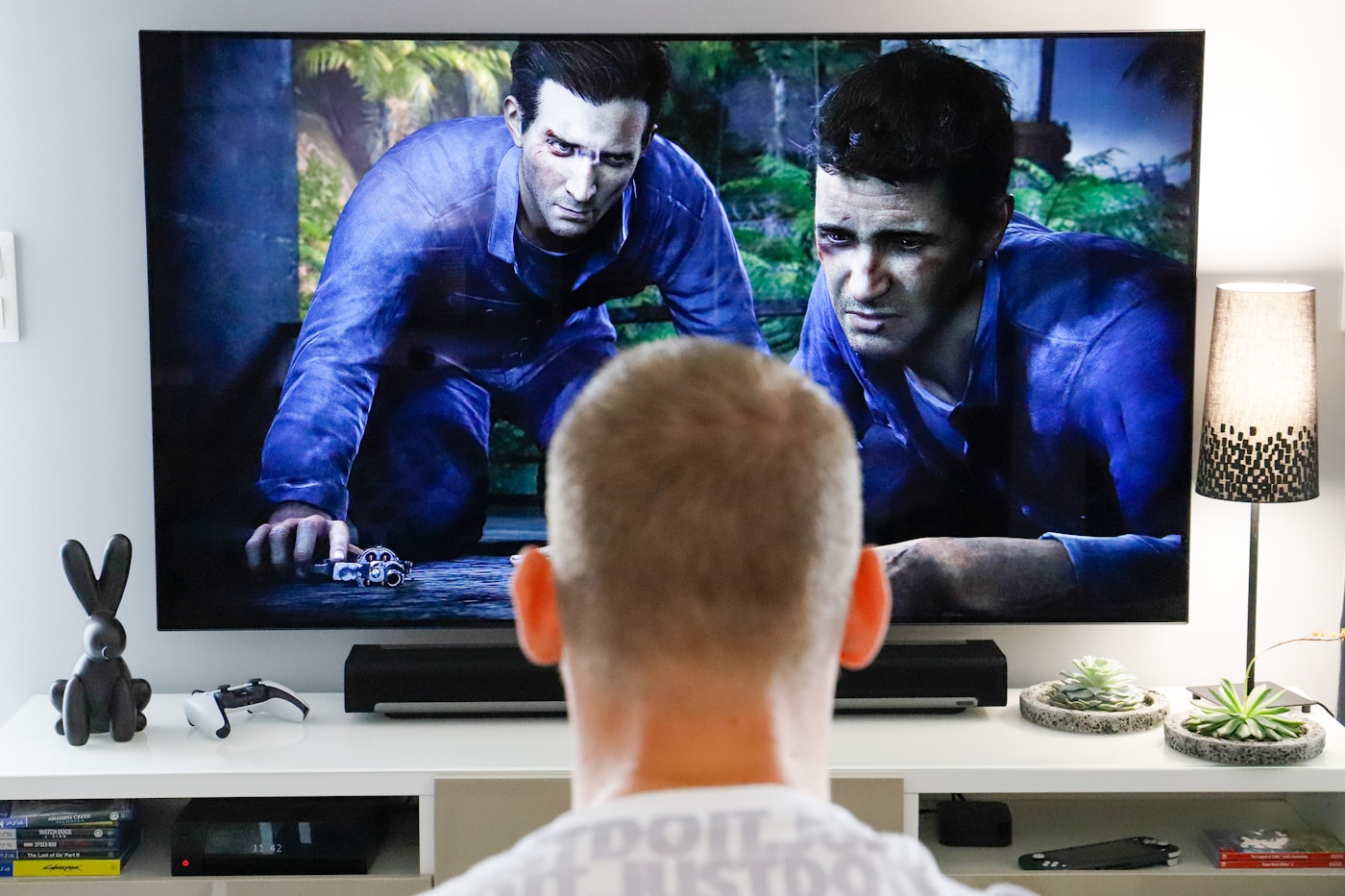 Persona viendo televisión IPTV en un salón con mando a distancia